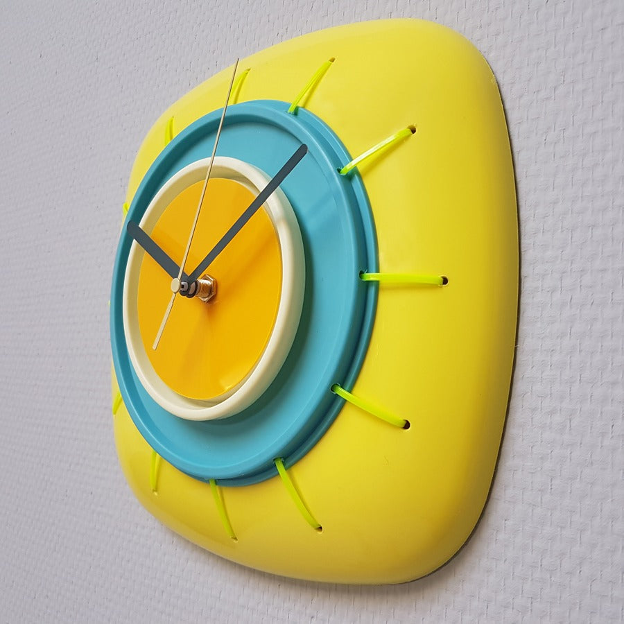 Klok in geel, aqua en oker